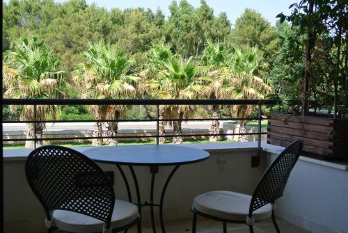 a table and chairs on a balcony with palm trees at Grand Hotel la Chiusa di Chietri in Alberobello