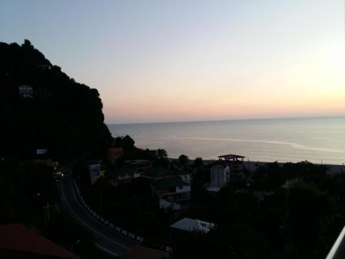 a view of the ocean from a city at sunset at Temo's guest house in Kvariati in Kvariati