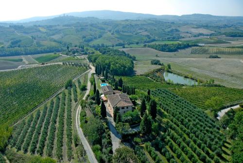 an aerial view of a vineyard with a house on a hill at Podere Remignoli in San Gimignano