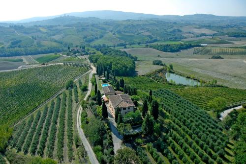 une vue aérienne sur un vignoble avec une maison sur une colline dans l'établissement Podere Remignoli, à San Gimignano