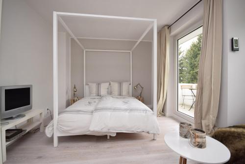 - une chambre avec un grand lit blanc et un grand miroir dans l'établissement Ferienwohnung Zweisamkeit, à Bad Harzburg