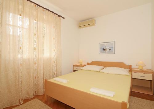 a white bedroom with a bed and a window at Marija Rooms in Dubrovnik