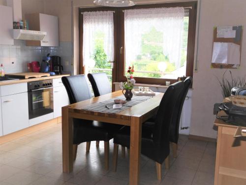 摩澤爾河畔的策爾的住宿－Fewo Winzerstrasse，厨房配有木桌和黑色椅子
