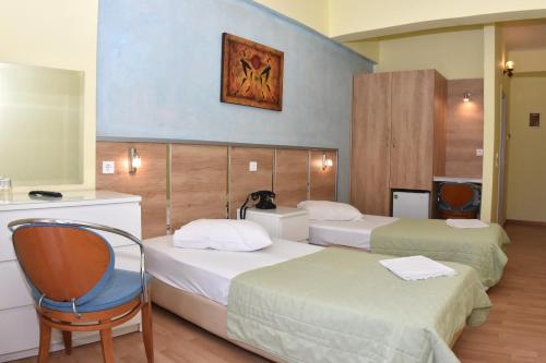 a hotel room with two beds and a chair at Socrates Hotel in Athens