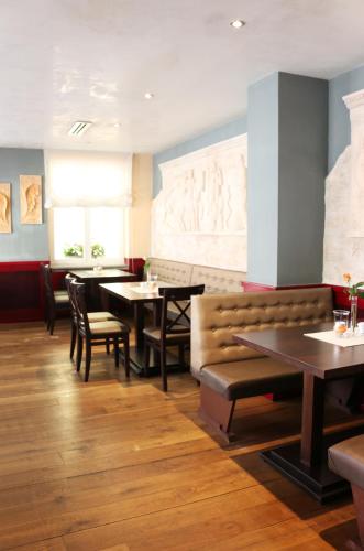 a dining room with tables and chairs in a restaurant at City Hotel in Schopfheim