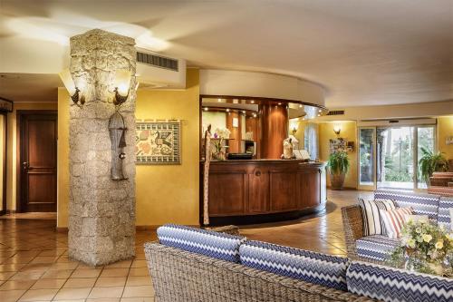 a lobby with couches and a column in a building at Cruccùris Resort - Adults Only in Villasimius