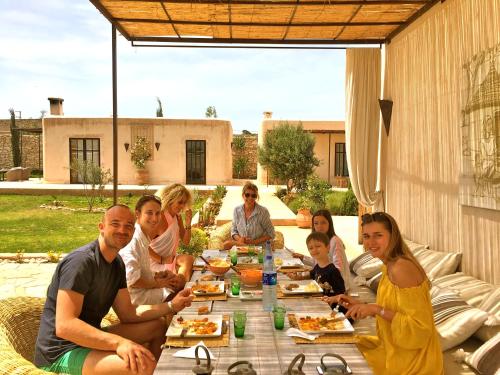 a group of people sitting around a table eating food at Dar Alya Essaouira Maison et table d'hôtes in Ghazoua