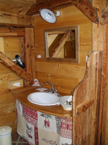 une salle de bain avec un lavabo dans une cabane en rondins dans l'établissement Le Grenier, à Saint-Paul-en-Chablais