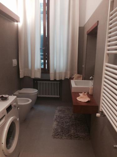 a bathroom with a toilet and a sink and a washing machine at Venetian House in Venice