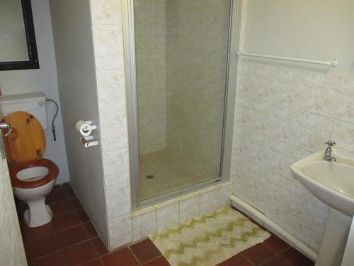 a bathroom with a shower with a toilet and a sink at Uberkei in Coffee Bay