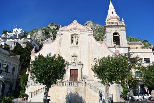 an old church with a mountain in the background at Bed & Breakfast La Rocca in Taormina