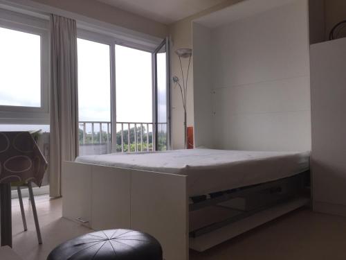 Bett in einem Zimmer mit einem großen Fenster in der Unterkunft Studio Heist in Knokke-Heist