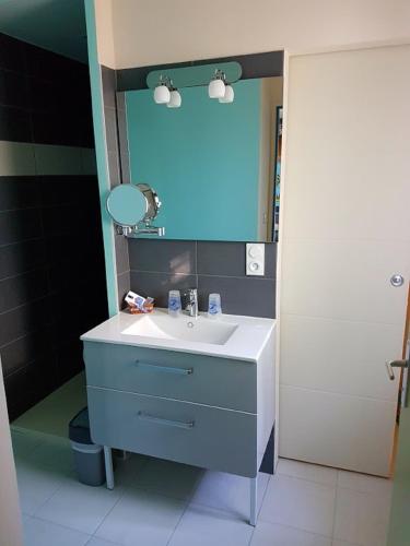 une salle de bain avec un lavabo et un miroir dans l'établissement La Belgerie, à La Bernerie-en-Retz