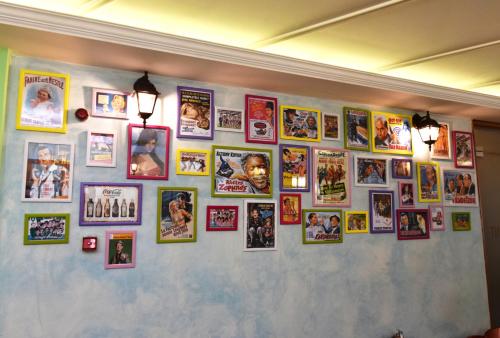 a wall with a bunch of pictures on it at Socrates Hotel in Athens