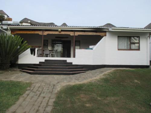 a white house with stairs and a porch at Uberkei in Coffee Bay
