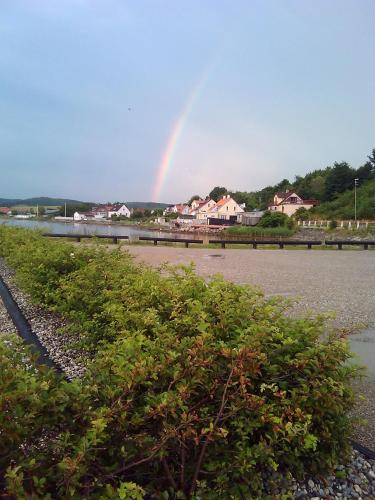 a rainbow in the sky over a body of water at Thorup Guesthouse in Knebel