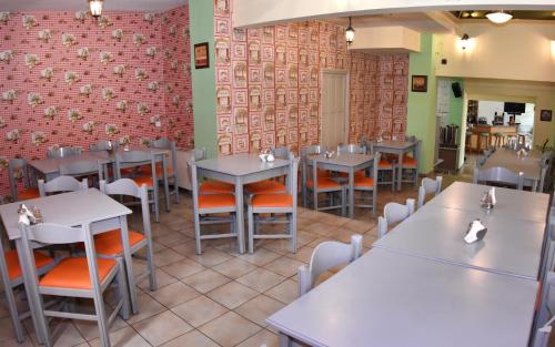 a restaurant with tables and chairs and a brick wall at Socrates Hotel in Athens