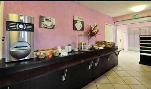 a restaurant with a counter in a room at Prim Hotel Reims nord in Witry-lès-Reims