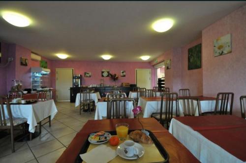 a restaurant with tables and chairs and a dining room at Prim Hotel Reims in Witry-lès-Reims