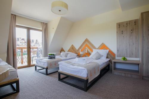 ビャウカにあるNovobilski - obok Termy Baniaのベッド2台と窓が備わるホテルルームです。