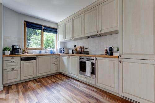 cocina con armarios blancos y suelo de madera en Silver & Gold Apartment, en Sofía