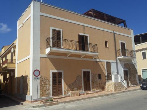 ein großes Gebäude mit zwei Balkonen auf einer Straße in der Unterkunft Le Pietre Di Lampedusa in Lampedusa
