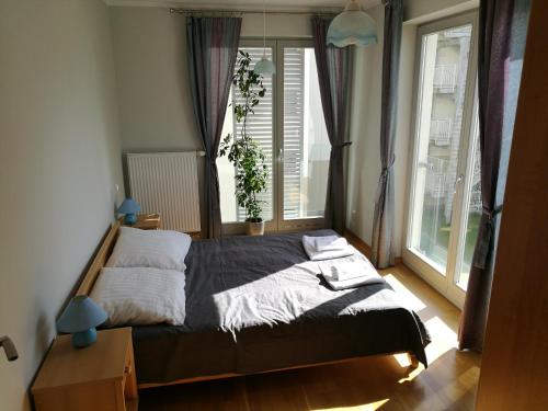 a bedroom with a bed and a large window at Apartament Świnoujście Casa Marina SPA in Świnoujście