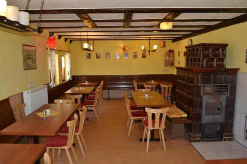 ein Restaurant mit Holztischen und -stühlen und einem Kamin in der Unterkunft Klügelhütte in Kurort Altenberg