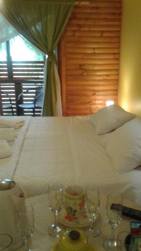 a bedroom with a bed with wine glasses on a table at La Maison des Fous in Papudo