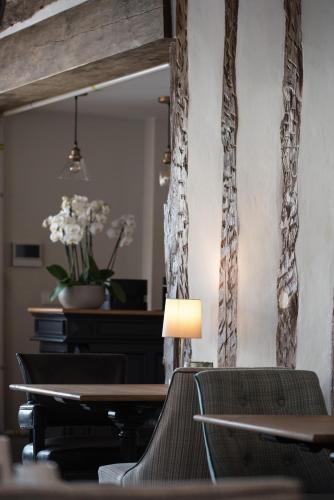 a table with chairs and a lamp in a room at Hôtel Le Chantilly in Chantilly