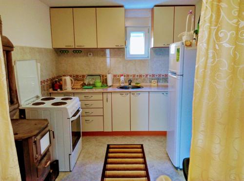 a kitchen with white cabinets and a white refrigerator at Apartman Anastasija in Žabljak