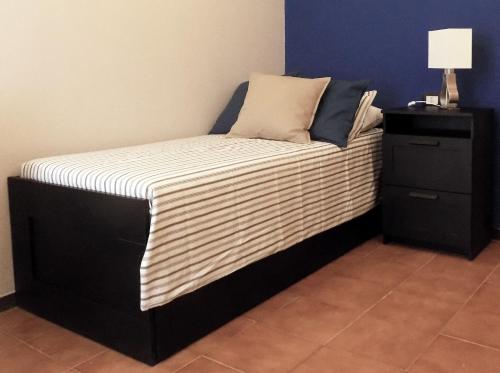 - un lit avec un matelas rayé et une table de nuit dans l'établissement Il Ristoro di Garibaldi, à La Spezia