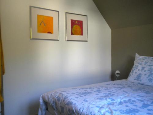 サン・マロにあるLa Cerisaieの壁に2枚の写真が飾られたベッドルーム1室、ベッド1台が備わります。