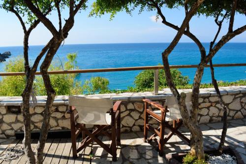 a table and chairs on a balcony with the ocean at Arenaria Leucadia in Agios Nikitas