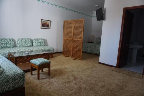 a living room with a couch and a chair at Hotel Zelis in Asilah