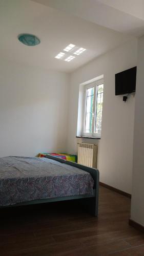 a bedroom with a bed and a television in a room at La vie est belle in Finale Ligure