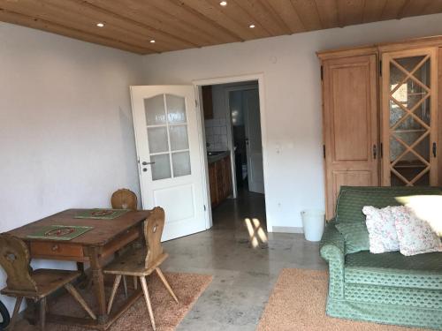 a living room with a wooden table and a couch at Landhotel Rangau Gasthof & Brennerei in Markt Erlbach