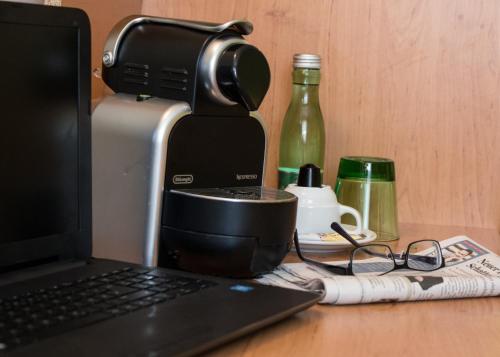 a laptop computer sitting on a desk next to a coffee maker at Hotel Kreuzwirt in Engerwitzdorf