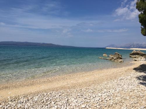 a beach with a rocky shoreline and the ocean at Apartments Evelin in Makarska