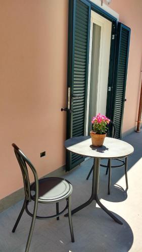 a table and chairs with a pot of flowers on it at La vie est belle in Finale Ligure