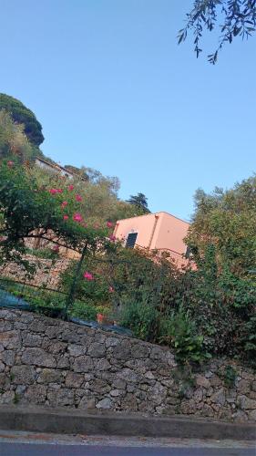a fence with pink flowers on the side of a road at La vie est belle in Finale Ligure