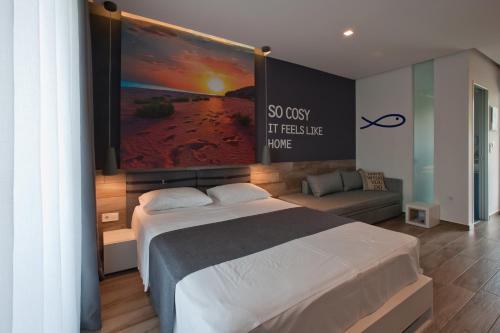 ein Schlafzimmer mit einem Bett mit einem großen Bildschirm darüber in der Unterkunft Chrysalis studios in Stavros