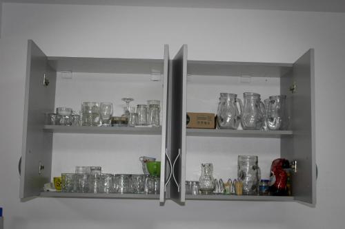 a shelf filled with glasses and other glass items at Complex Turistic Dávid in Boghiş