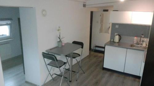 グディニャにあるHoliday Flat - Attic Apartment Gdynia Oksywieの小さなキッチン(テーブル、椅子付)