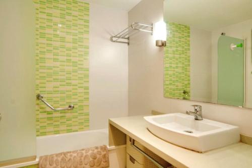 a bathroom with a sink and a mirror and a tub at Park Beach Benalmadena in Benalmádena