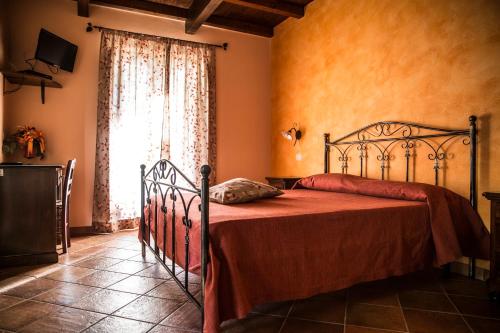 a bedroom with a bed with a red blanket and a window at Agriturismo Aurea in Torretta