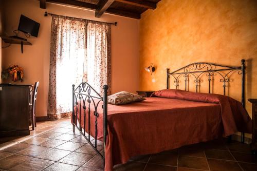 TorrettaにあるAgriturismo Aureaのベッドルーム1室(赤毛布、窓付)