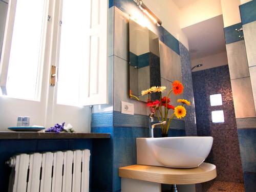 a bathroom with a sink and a vase with flowers on a stool at Antonio Massa Lubrense in Massa Lubrense
