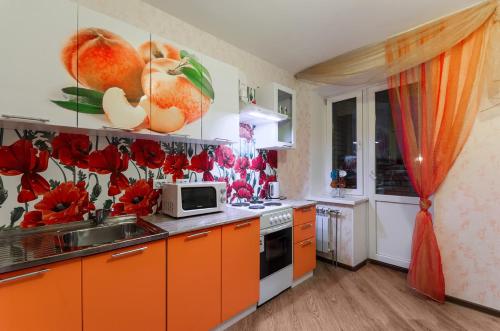 uma cozinha com armários laranja e um lavatório em Apartment on Perevertkina 1/7 em Voronezh