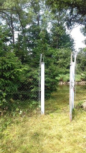 a pair of gates in a field next to a fence at Chata Zahrada Madeta in Veselí nad Lužnicí